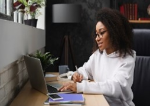 A woman sitting at a table with a laptop.