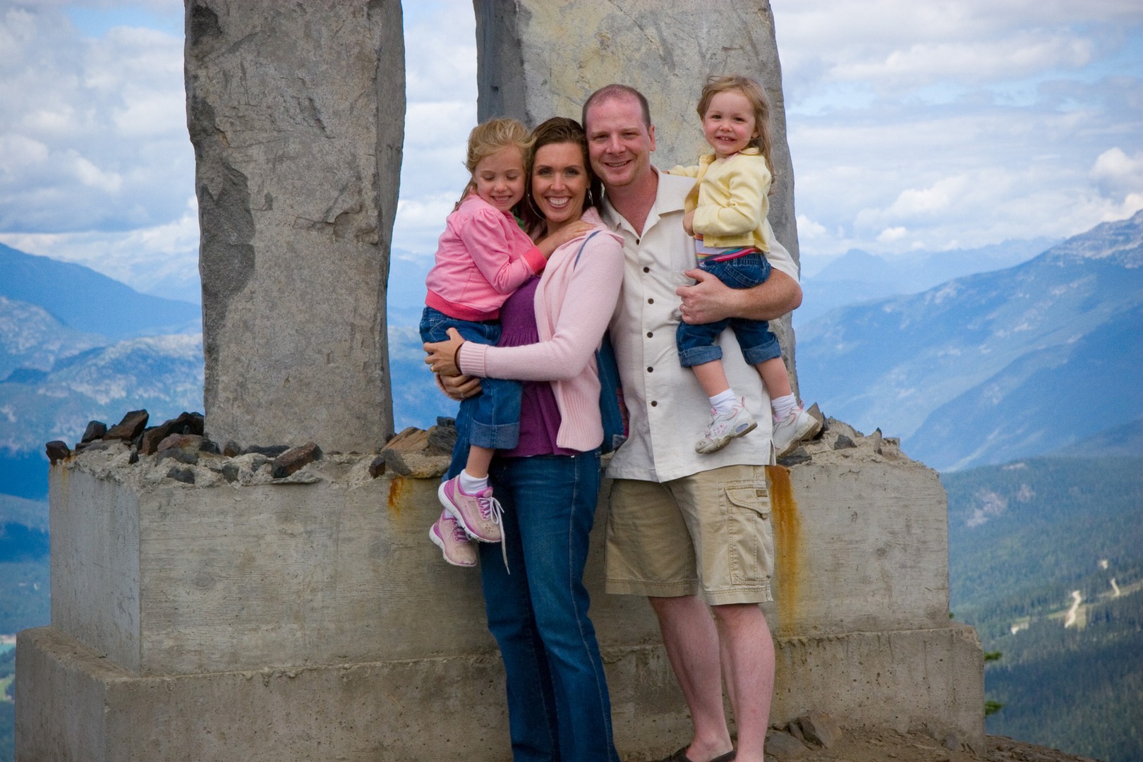 A family posing for the camera on top of a mountain.