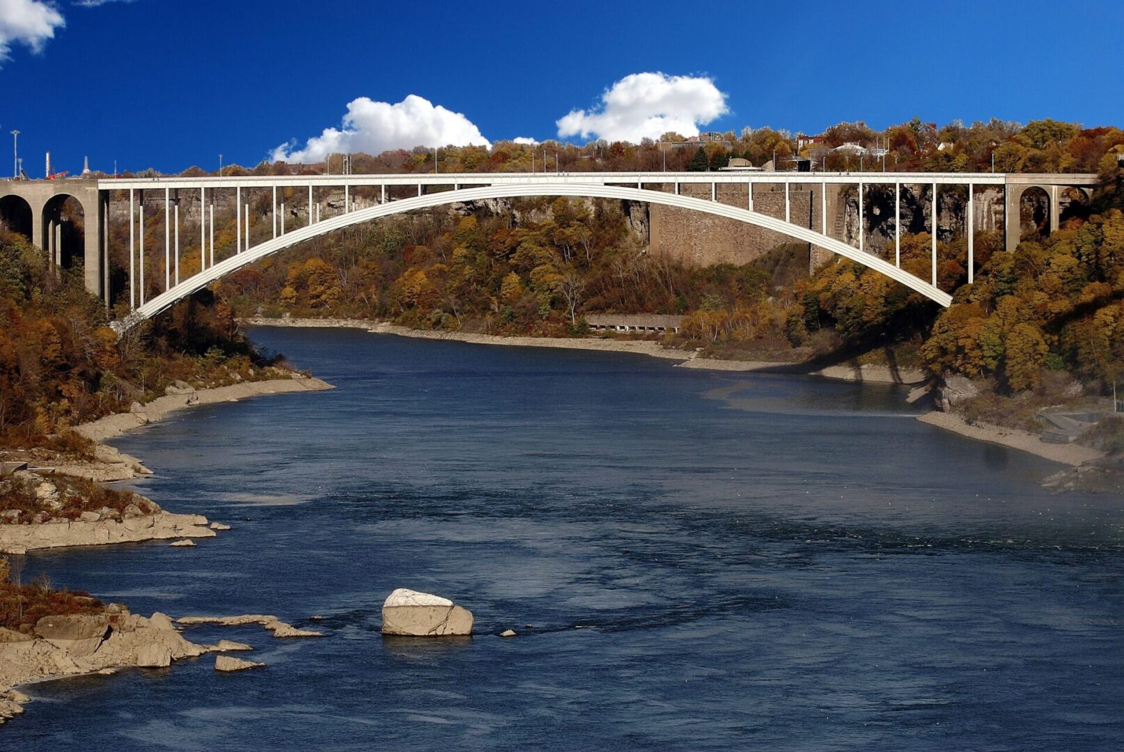 A bridge over the water with trees in the background