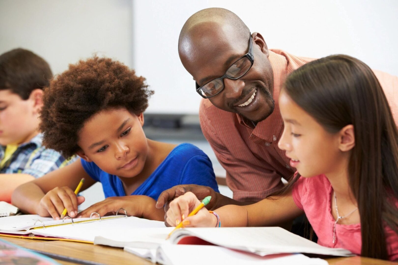 A man and two children are doing homework together.