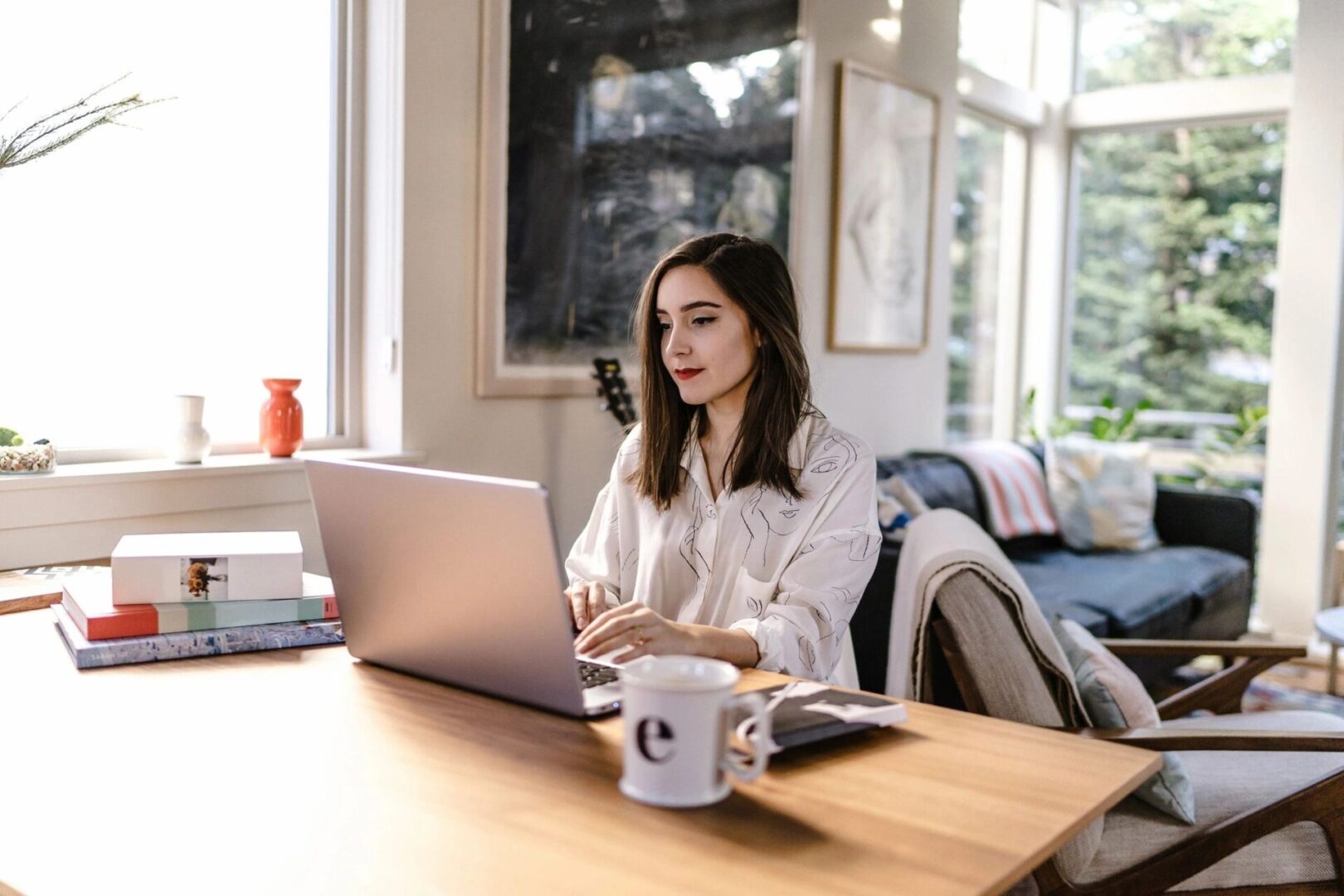 A woman sitting at a table with a laptop.