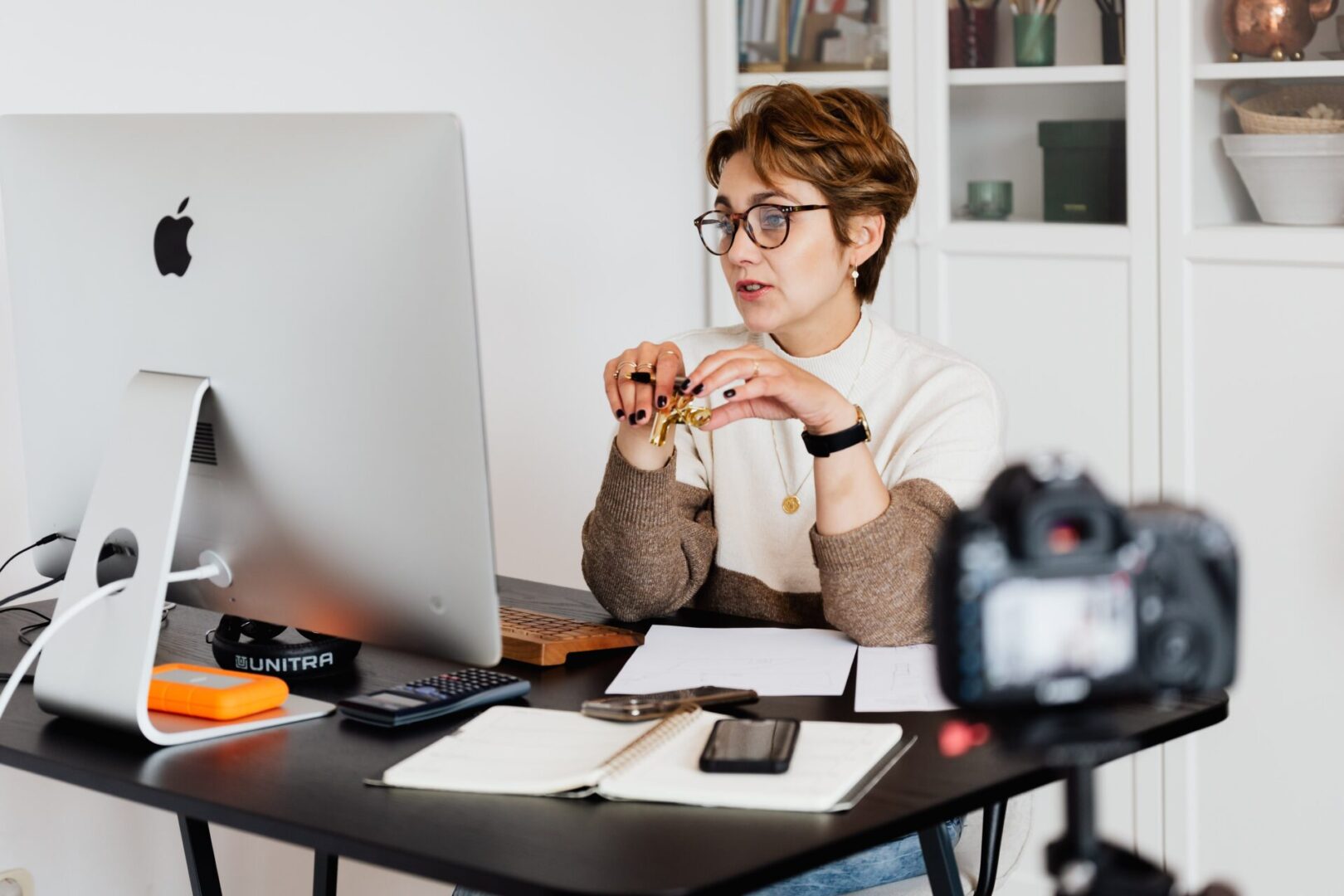 A woman sitting at her desk with a camera